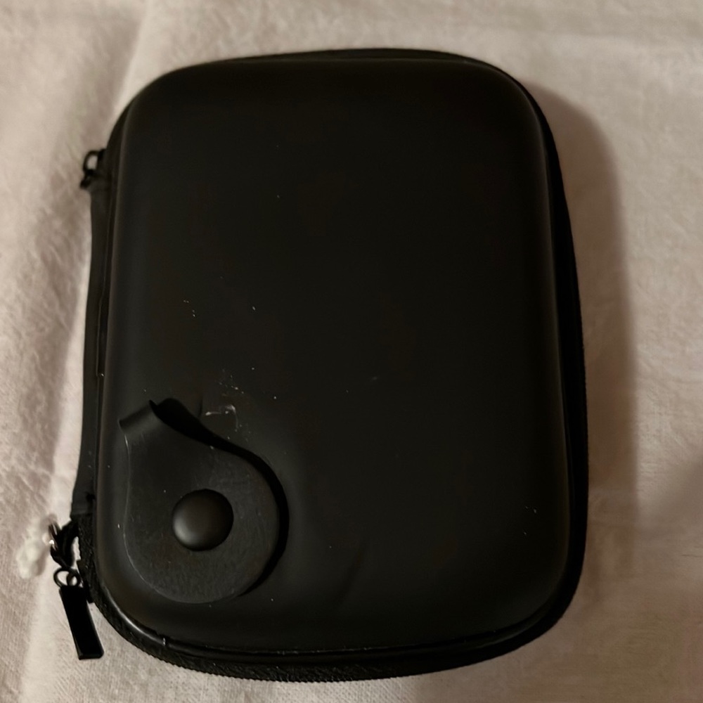 Small, hard shell travel case 6”w x 4.5”h.